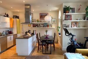 een keuken en eetkamer met een tafel en stoelen bij Stylish & Homely 1BD Flat 1min to Clapton Sqaure! in Londen