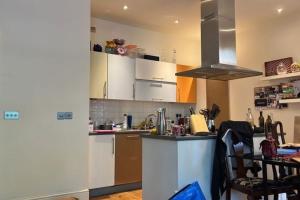 a kitchen with white cabinets and a counter top at Stylish & Homely 1BD Flat 1min to Clapton Sqaure! in London