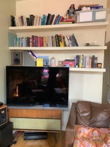 een grote flatscreen-tv in de woonkamer bij Stylish & Homely 1BD Flat 1min to Clapton Sqaure! in Londen