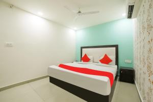 a bedroom with a bed with red pillows at OYO My Comfortable Hotel in New Delhi