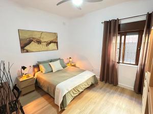 1 dormitorio con cama y ventana en Apartamento El Patio, en Chipiona