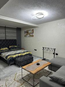 a living room with a bed and a coffee table at Lavanda Apartman in Novi Pazar +8 photos