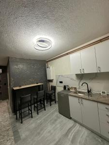 uma cozinha com um lavatório, uma mesa e cadeiras em Lavanda Apartman em Novi Pazar
