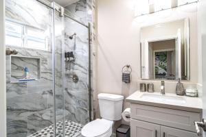 a bathroom with a shower and a toilet and a sink at Amazing Value with High Comfort, 14 Guests for 4BR by Disneyland, Beaches, Rodeo 39 & More in Midway City +26 photos