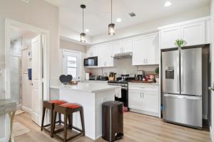 a kitchen with white cabinets and a stainless steel refrigerator at Amazing Value with High Comfort, 14 Guests for 4BR by Disneyland, Beaches, Rodeo 39 & More in Midway City