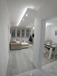 uma sala de estar branca com um sofá e uma mesa em Konak Cicović em Pale