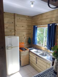 uma cozinha com um frigorífico branco e um lavatório em Recanto Pé da Serra em Santo Amaro da Imperatriz