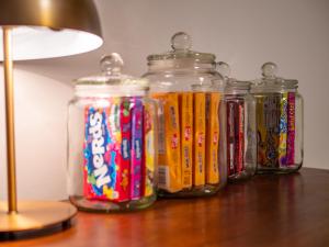 four glass jars sitting on a table next to a lamp at The Emerald Manor in Cleveland