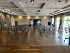 an empty room with chairs and tables and a large hall at Landhotel Krummenweg in Ratingen