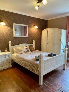 The Old House في مالبورك: غرفة نوم مع سرير أبيض مع خزانة ومرآة