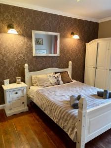 The Old House في مالبورك: غرفة نوم مع سرير أبيض ومرآة على الحائط
