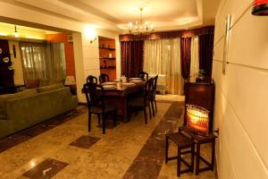 a living room with a table and chairs and a couch at Luxury Apartment 6 min to Airport snacks included. in Cairo