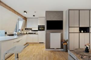 a kitchen with white cabinets and a table at Modern Elegance in historical City Center in Trier