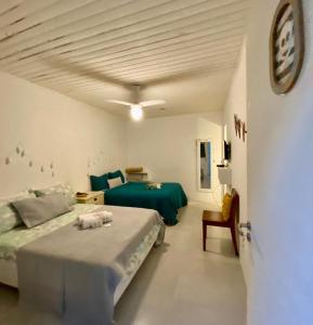 a bedroom with two beds and a green bed at SUÍTES Caminho do Mar in Abraão