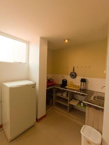 a kitchen with a white refrigerator and a sink at Apartamento Mirador San Blas in Cusco