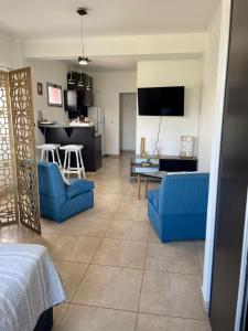 a living room with blue couches and a kitchen at Punto Maschwitz Alquileres - Monoambiente in Ingeniero Maschwitz