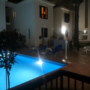 a swimming pool at night in a house at Seashell Apartments in Paphos