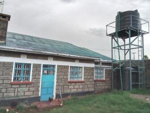 an old building with a water tower next to it at Sam & Miriam's Homestay in Nakuru