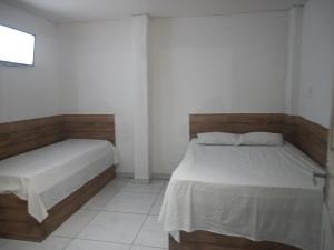 a bedroom with two beds in a room at Pousada Encontro das Águas in Paripueira
