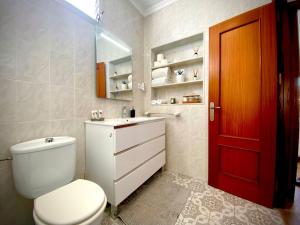 a bathroom with a white toilet and a red door at MyChoice Villa Almadraba in Rota +61 photos