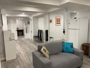 uma sala de estar com um sofá e um frigorífico em Large Separate Entrance Basement Unit 2Beds 1Washroom Sleeps 4-6 em Pickering