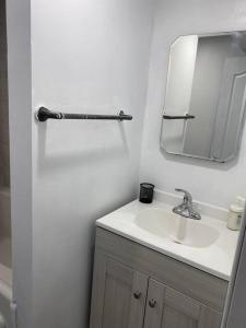 Baño blanco con lavabo y espejo en Large Separate Entrance Basement Unit 2Beds 1Washroom Sleeps 4-6 en Pickering