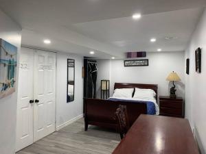 1 dormitorio con cama, mesa y puerta en Large Separate Entrance Basement Unit 2Beds 1Washroom Sleeps 4-6, en Pickering