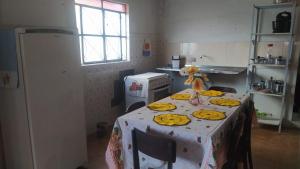 uma cozinha com uma mesa com pratos de comida em Casa Gaita - Temporada em Triunfo