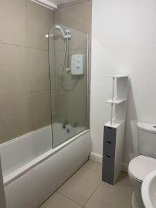 a bathroom with a shower and a toilet at Stylish 3-Bed Gem in Romiley Newly Renovated, En Suite Comfort, Courtyard Charm, and Effortless Parking in Romiley
