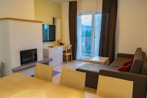 uma sala de estar com um sofá e uma televisão em Apartmajska hiša Breza em Ribnica na Pohorju