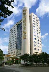 un gran edificio blanco con un cartel. en Sunshine Holiday Hotel Fuzhou, en Fuzhou
