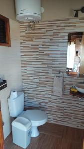 a bathroom with a toilet and a brick wall at Lugar de descanso ideal, Paraiso al lago, Ypacarai - Central in Ypacarai