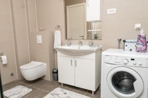 a bathroom with a washing machine and a sink at HH apartments in Bjelašnica +33 photos