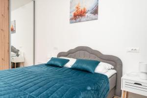a bedroom with a bed with a blue comforter at HH apartments in Bjelašnica