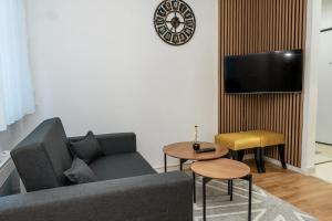 a living room with a couch and a tv at HH apartments in Bjelašnica