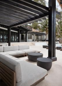 a patio with couches and tables and a building at Villa Abrazos in San Pedro