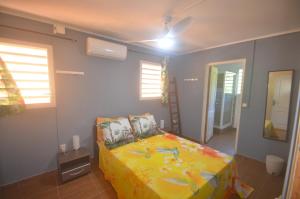 a bedroom with a bed and a ceiling fan at Bougain Fleuri in Deshaies