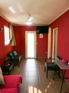 a living room with red walls and a couch at Bougain Fleuri in Deshaies