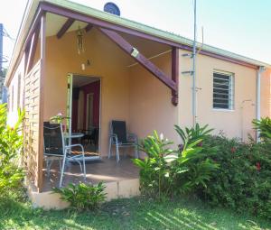 a porch of a house with chairs and a table at Bougain Fleuri in Deshaies