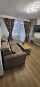 a living room with a couch and a table at Urban Retreat Central - One bedroom apartment in Piteşti