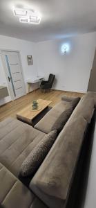 a large couch in a living room with a table at Urban Retreat Central - One bedroom apartment in Piteşti