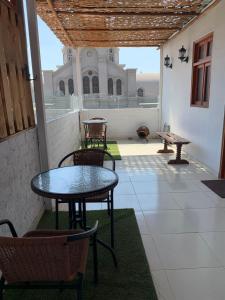 patio ze stołem i krzesłami oraz budynek w obiekcie Hamuy's Lodge w mieście Ica
