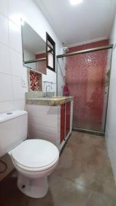 een badkamer met een wit toilet en een douche bij Apartamento a Duas Quadras da Praia in Cabo Frio