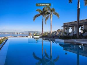 een zwembad met palmbomen in een resort bij Amazing apartment with Rooftop Pool in Puerto Vallarta