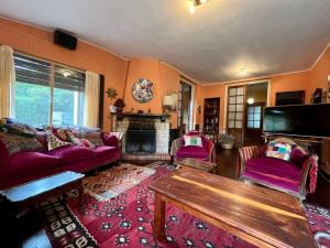 - un salon avec des canapés violets et une cheminée dans l'établissement La Bedoya, à La Cumbre