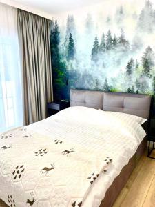 a bedroom with a bed with a painting on the wall at Flora & Sauna Kamieńczyk Konwaliowa 8 