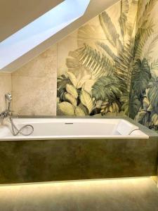 a bath tub in a bathroom with a mural at Flora & Sauna Kamieńczyk Konwaliowa 8 in Błonie