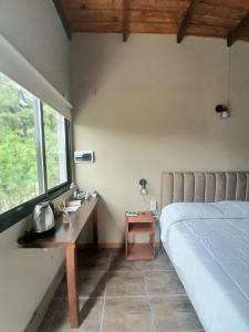 - une chambre avec un lit, un bureau et une fenêtre dans l'établissement Olivos de Monte, à San Miguel del Monte