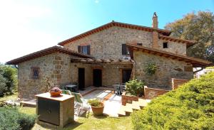 an external view of a stone house with a patio at Agriturismo Podere 3 Querce in Manciano