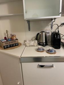 eine Küchentheke mit einem Wasserkocher und Tassen in der Unterkunft Mini appartamento” La Casetta” in Cosenza